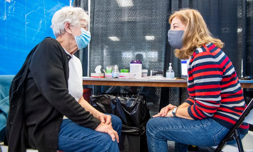 Iva Gloss talks Wednesday with Anne Fuson, a registered nurse at IU Health Bloomington, before getting her second dose at the COVID-19 vaccination clinic in the Monroe Convention Center. (Rich Janzaruk / Herald-Times)