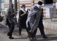 A family arrive to identify body of their family member, who was killed in the Friday's plane crash, at a morgue in Karachi, Pakistan, Saturday, May 23, 2020. An aviation official says a passenger plane belonging to state-run Pakistan International Airlines carrying passengers and crew has crashed near the southern port city of Karachi. (AP Photo/Fareed Khan)