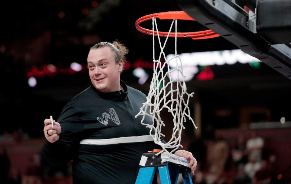 South Carolina head athletic trainer Craig Oates cuts down the net at Bon Secours Wellness Arena after the Gamecocks’ 2023 SEC Tournament championship win.