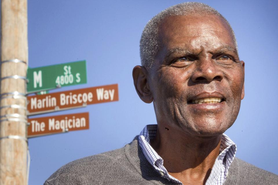 FILE - In this Oct. 22, 2014, file photo, Marlin Briscoe stands in front of a street that was renamed for him in Omaha, Neb. The Pro Football Hall of Fame calls the Omaha, Neb. native the first black quarterback in the modern era of pro football. He opened the door for many, including Carolina's Cam Newton and Seattle's Russell Wilson, who both pay homage to him. (Kent Sievers/Omaha World-Herald via AP, File)