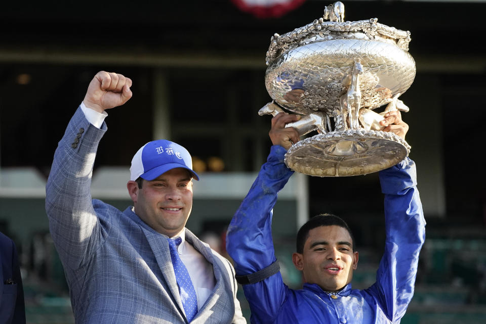 Trainer Brad Cox, left, and jockey Luis Saez pose for a photo with the August Belmont Trophy after winning the 153rd running of the Belmont Stakes horse race with Essential Quality (2), Saturday, June 5, 2021, at Belmont Park in Elmont, N.Y. (AP Photo/Seth Wenig)