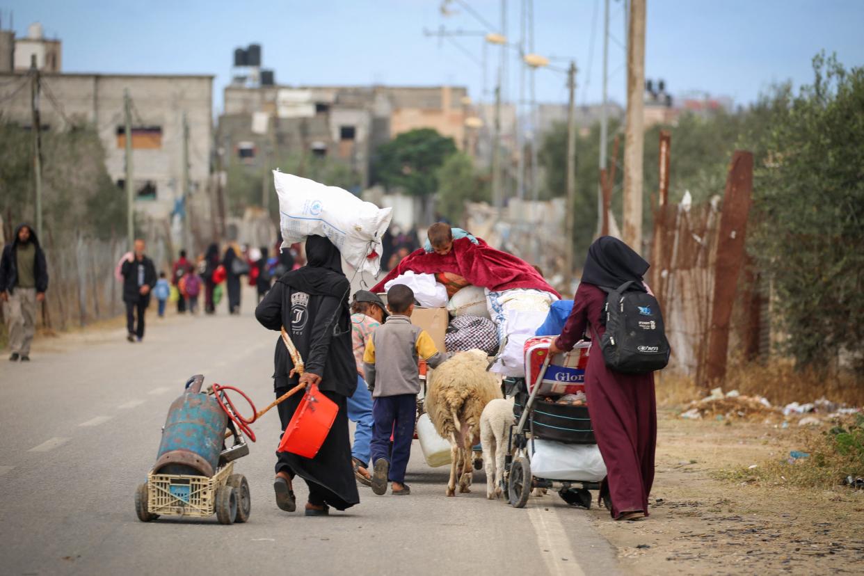 Displaced Palestinians in Rafah carry their belongings as they leave following an evacuation order by the Israeli army on Monday.