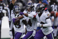 Baltimore Ravens cornerback Marlon Humphrey (44) celebrates after intercepting a pass, during an NFL football game against the Cleveland Browns, Sunday, Sept. 13, 2020, in Baltimore. To the right Baltimore Ravens safety DeShon Elliott (32) and cornerback Tavon Young (25), left. (AP Photo/Julio Cortez)