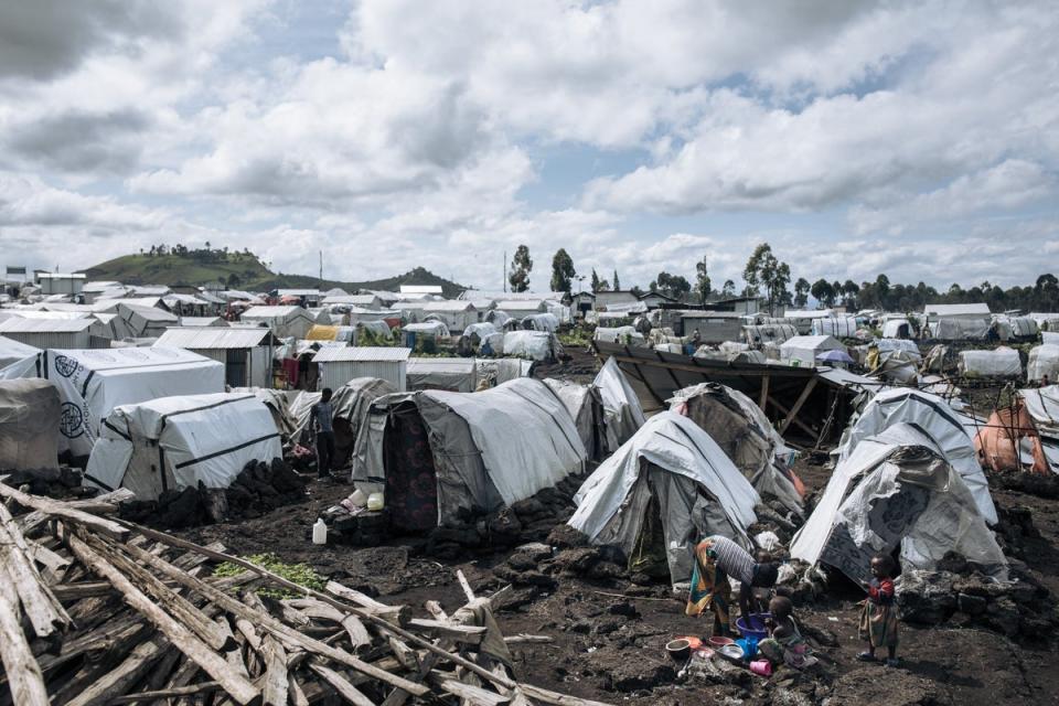 Displaced children wash dishes in the Bulengo camp for war-displaced people, near a front line on the western outskirts of Goma (AFP via Getty Images)