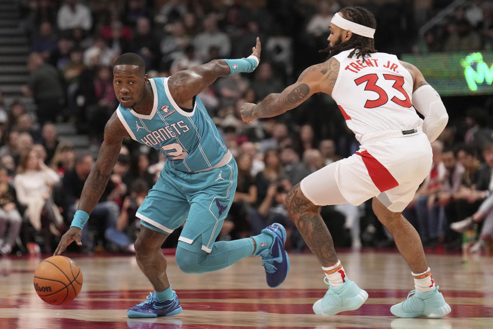 Charlotte Hornets guard Terry Rozier (3) tries to fend off Toronto Raptors guard Gary Trent Jr. (33) during first-half NBA basketball game action in Toronto, Monday, Dec. 18, 2023. (Nathan Denette/The Canadian Press via AP)