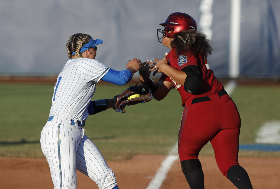 UCLA's Taylor Pack, left, tags out Oklahoma's Jocelyn Alo at first base in the first inning of Game 2 of the best-of-three championship series in the NCAA softball Women's College World Series in Oklahoma City, Tuesday, June 4, 2019. (AP Photo/Alonzo Adams)