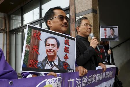 Members from the pro-democracy Civic Party carry a portrait of Lee Bo (L) and Gui Minhai before they protest outside Chinese Liaison Office in Hong Kong, China January 19, 2016. REUTERS/Bobby Yip