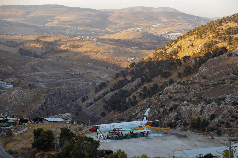 A Boeing 707 aircraft has been converted to a cafe, in Wadi Al-Badhan, just outside the West Bank city of Nablus, Aug. 11, 2021. Few Palestinians in the occupied West Bank get to board an airplane these days. The territory has no civilian airport and those who can afford a plane ticket must catch their flights in neighboring Jordan. But twins brothers, Khamis al-Sairafi and Ata, are offering people the old airplane for customers to board. (AP Photo/Majdi Mohammed)