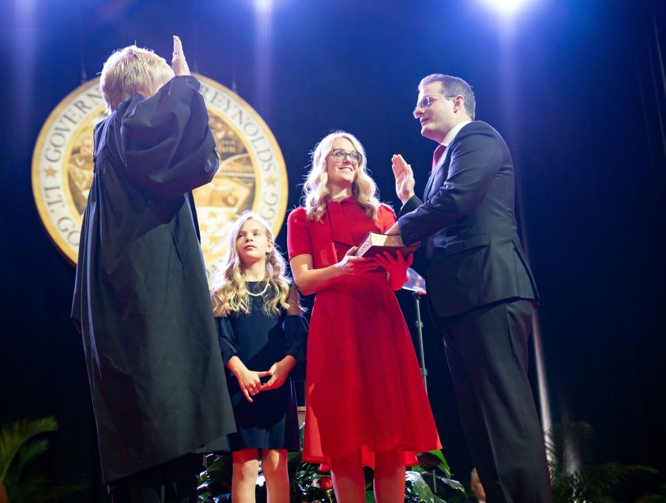 Iowa Supreme Court Chief Justice Susan Christensen, left, administers the Oath of Office to Lt. Gov. Adam Gregg, right, as his wife, Cari, center holds the Bible, during inauguration ceremonies, Friday, Jan. 13, 2023.