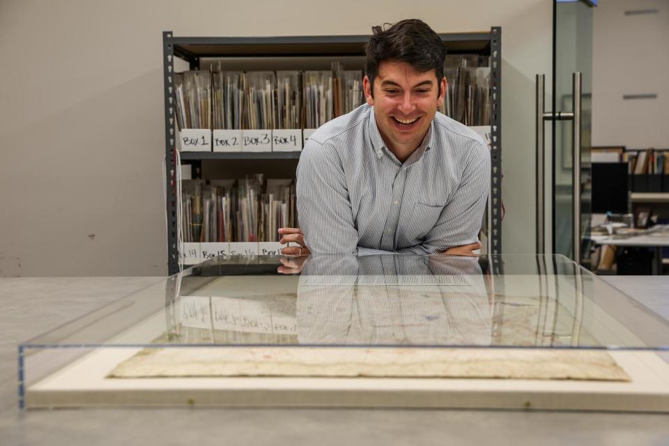 Map dealer Alex Clausen surveys a 14th century portolan chart.