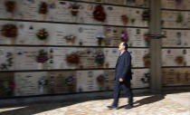 Rev. Mario Carminati walks in a cemetery in Seriate, near Bergamo, Italy, Sunday, Sept. 27, 2020. As the world counts more than 1 million COVID victims, the quiet of everyday life and hum of industry has returned to Bergamo, which along with the surrounding Lombardy region was the onetime epicenter of the outbreak in Europe. But the memory of those dark winter days, and the monumental toll of dead they left behind, has remained with those who survived only to see the rest of the world fall victim, too. (AP Photo/Antonio Calanni)