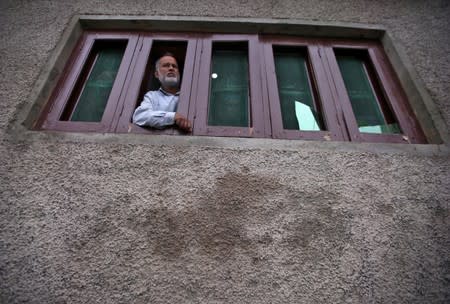 Kashmiri man looks out from a window of his house which was allegedly damaged by Indian security forces after clashes between protesters and the security forces on Friday evening, in Srinagar