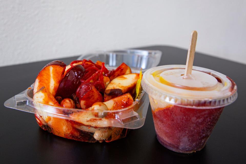 A $8 manzanas locas, left, consists of apple, Japanese peanuts, Tajin, chamoy, Valentina sauce, tamarind candy and chamoy candy with a chamoy sauce. Ruben's also offers a $2.50 mangonada popsicle.