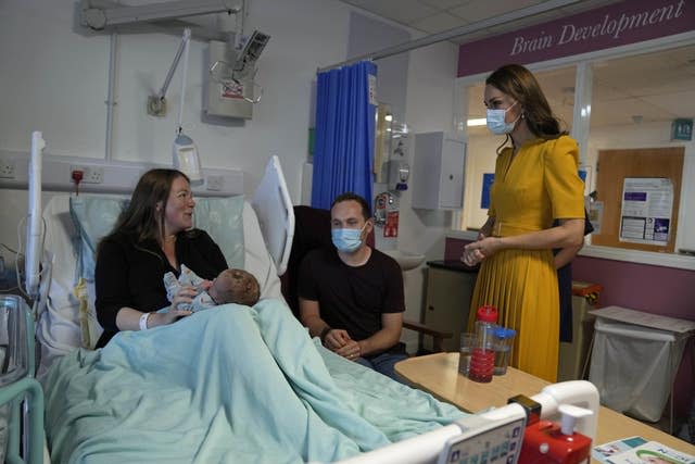 The Princess of Wales speaks to Andrew and Jessica Kemp with baby Hugo during a visit to the Royal Surrey County Hospital’s maternity unit in Guildford