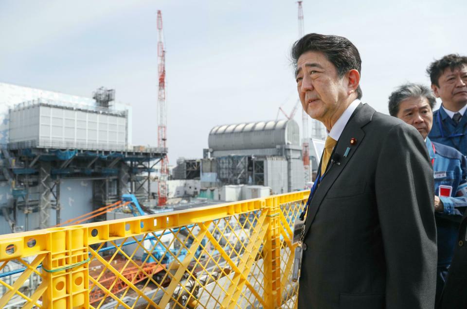 Japanese Prime Minister Shinzo Abe visits Fukushima Dai-ichi nuclear power plant in Okuma, Fukushima prefecture, Japan, Sunday, April 14, 2019, to inspect the reconstruction effort following the tsunami, quake and nuclear accident in 2011. (Kyodo News via AP)