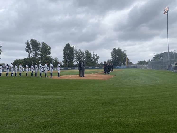 Birmingham and JSerra players standing for the national anthem on a cloudy Tuesday in Lake Balboa.