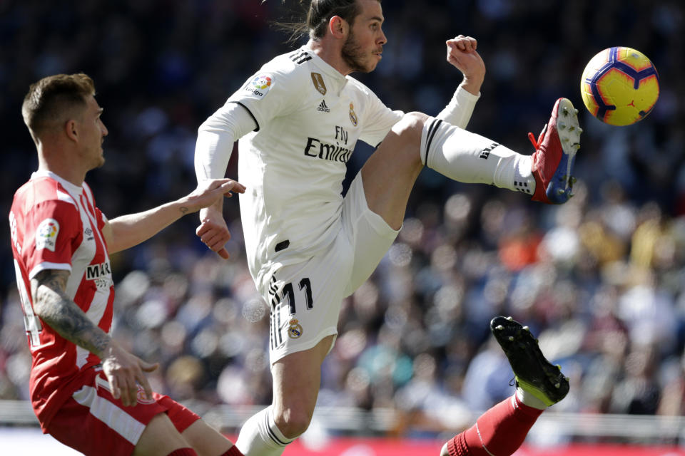 Gareth Bale, del Real Madrid, derecha, controla un balón frente a Raúl García Carnero del Girona durante un partido en el estadio Santiago Bernabeu por la 24ta jornada de la Liga española de fútbol, Madrid, domingo 17 de febrero de 2019. Girona ganó 2-1. (AP Foto/Andrea Comas)