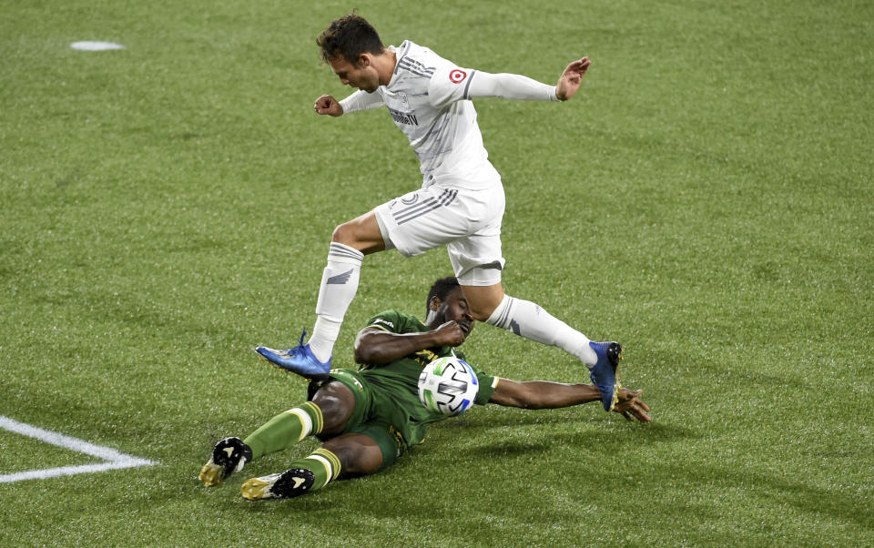 Portland Timbers defender Larrys Mabiala, bottom, slide tackles Los Angeles FC forward Danny Musovski during the first half of an MLS soccer match in Portland, Ore., Sunday, Oct. 18, 2020. (AP Photo/Steve Dykes)