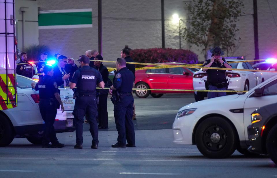 Officers and investigators work a scene where a person and an IMPD officer were shot just before 6 p.m. on Thursday, Oct. 26, 2023, near the intersection of East 21st Street and North Shadeland Avenue in Indianapolis. The person was left in critical condition and the officer sustained a "graze wound," according to IMPD.