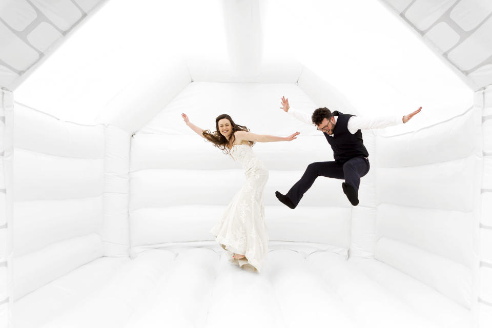 Tor and Duncan Cox jumping for joy in their wedding bouncy castle.&nbsp; (Photo: <a href="https://www.alextozeweddings.co.uk/" target="_blank">Alex Toze</a>)