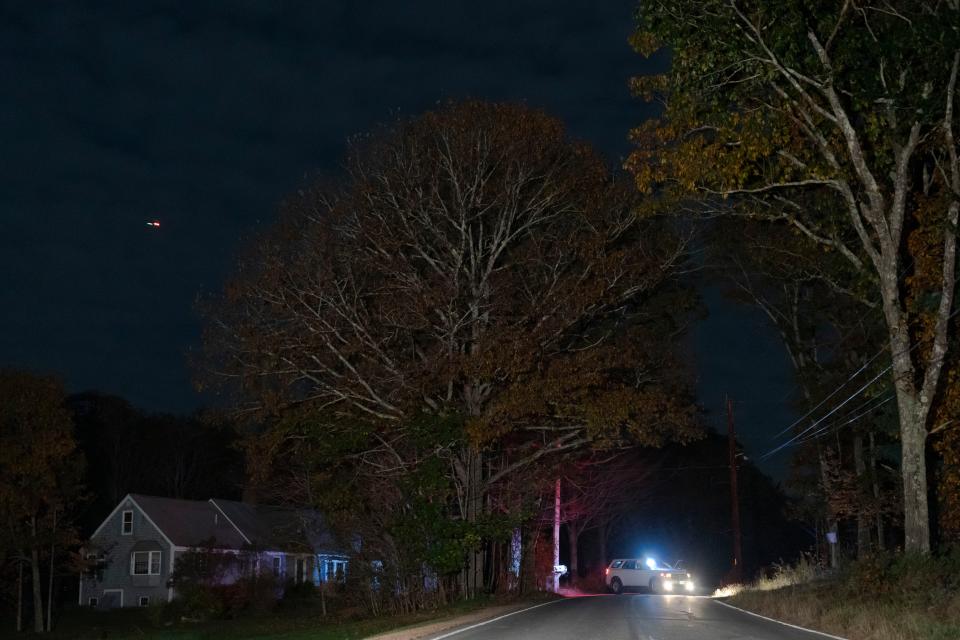A law enforcement officer blocks a road in Bowdoin, Maine, Thursday, Oct. 26, 2023, during a manhunt for the suspect of a mass shooting in Lewiston, Maine. (AP Photo/Matt Rourke)