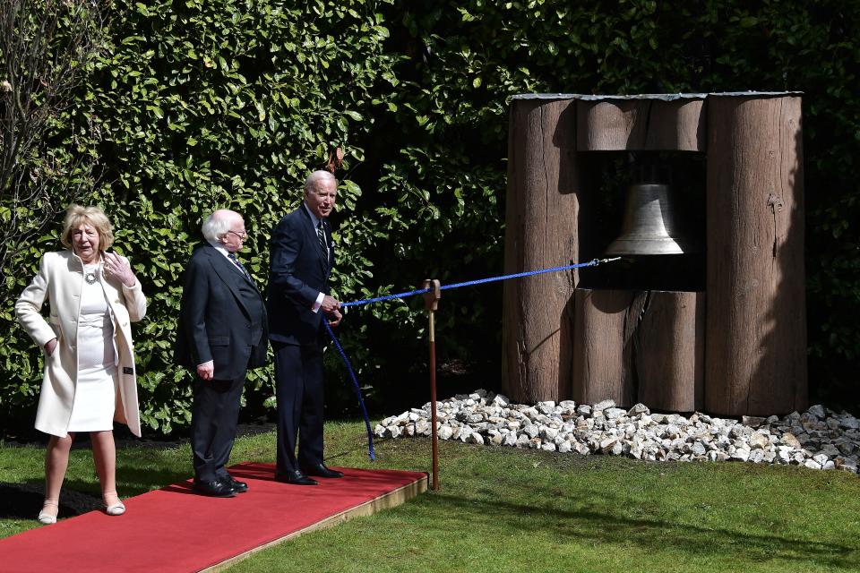 President Joe Biden, watched by Irish President Michael D Higgins and his wife Sabina Higgins, rings the Bell of Peace in the grounds of the Irish President's official residence Áras an Uachtaráin on April 13, 2023 in Dublin, Ireland.
