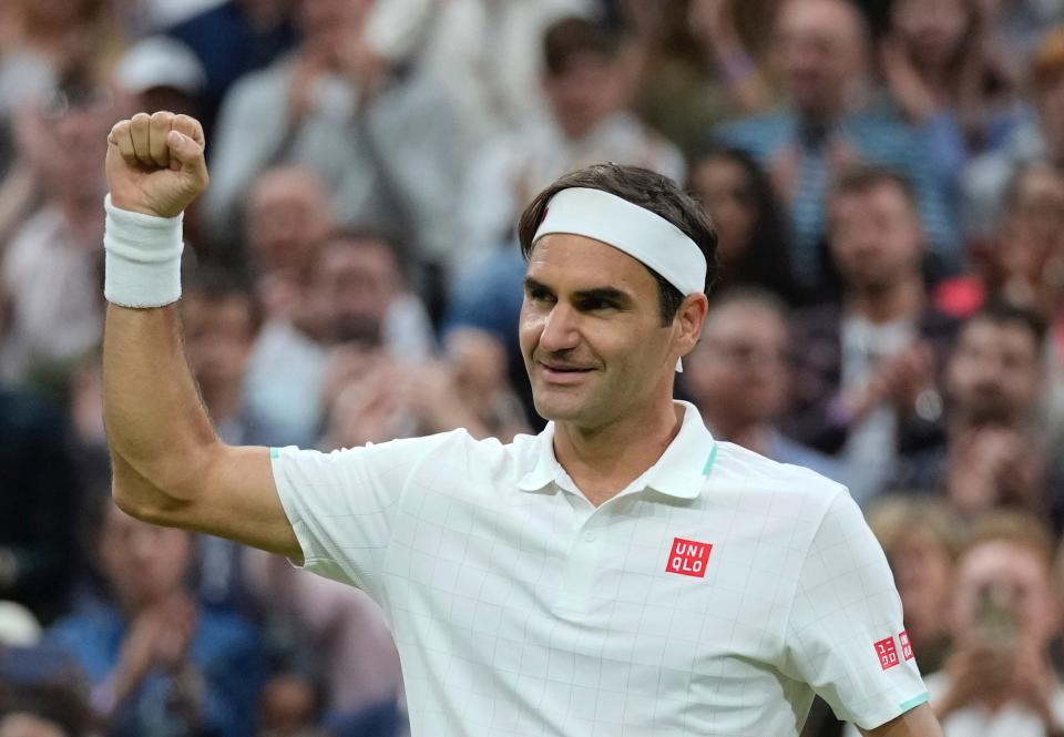 Roger Federer holds up his fist and smiles during Wimbledon in 2021.