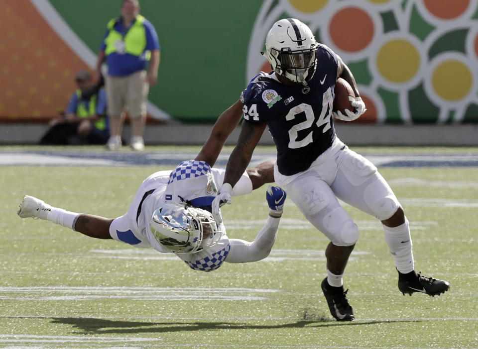 Kentucky safety Davonte Robinson, left, stops Penn State running back Miles Sanders (24) after a short gain during the first half of the Citrus Bowl NCAA college football game, Tuesday, Jan. 1, 2019, in Orlando, Fla. (AP Photo/John Raoux)