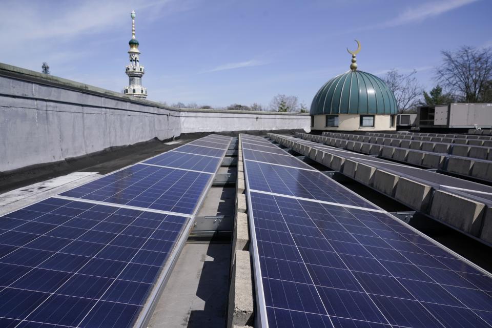 Solar panels cover the roof of Masjid Al-Wali, a mosque and community center, in Edison, N.J., Tuesday, April 11, 2023. Several years ago, Masjid Al-Wali, whose activities include an Islamic school and monthly community dinners, installed solar panels, which generate some of its energy use. (AP Photo/Seth Wenig)