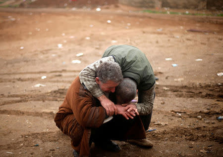 An Iraqi father (L) mourns the death of his son, who was killed during clashes in the Islamic State stronghold of Mosul, in al-Samah neighborhood, Iraq December 1, 2016. REUTERS/Mohammed Salem