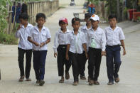 Schoolboys walk from class in Phnom Penh, Cambodia, Friday, April 26, 2019. Phnom Penh, Cambodia. Cambodian authorities have ordered a one-hour reduction in the length of school days because of concerns that students and teachers may fall ill from a prolonged heat wave. (AP Photo/Heng Sinith)