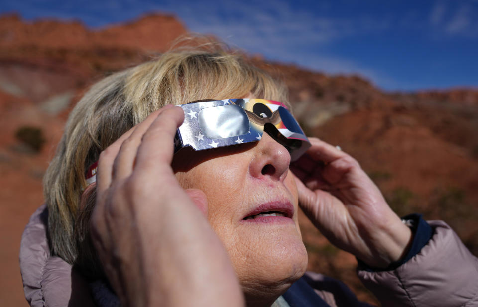 A woman looks at the sun with solar glasses after the Annular Solar Eclipse completed in Capitol Reef National Park, Utah.  / Credit: George Frey / Getty Images