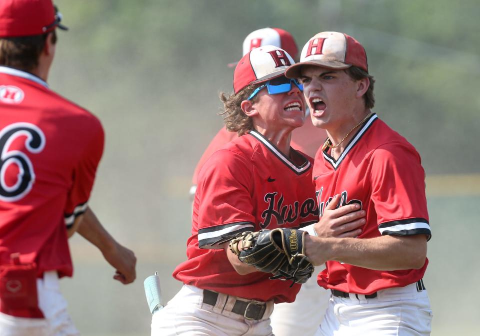 Gavin O'Hara (right) and Tyler Ramsby of New Boston Huron celebrate after getting the final out in the bottom of the seventh inning in the finals of the División 2 District at Airport Saturday. Huron won 4-1 in 10 innings.