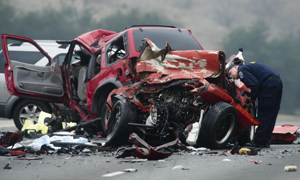 Officials investigate the scene of a multiple vehicle accident where 6 people were killed on the westbound Pomona Freeway in Diamond Bar, Calif. on Sunday morning, Feb. 9, 2013. Authorities say a wrong-way driver caused the pre-dawn crash that left six people dead. (AP Photo/San Gabriel Valley Tribune,Watchara Phomicinda) MAGS OUT, NO SALES MANDATORY CREDIT