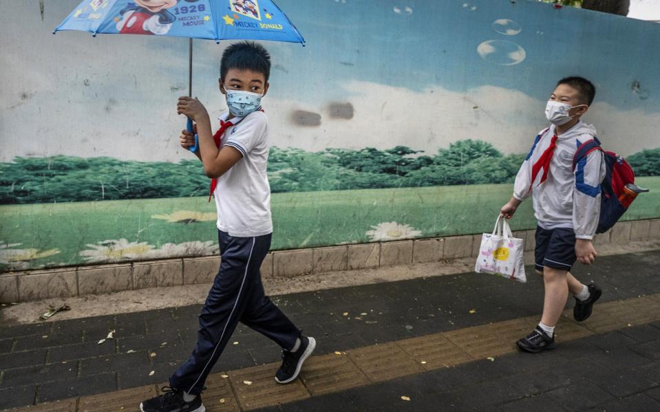 Pupils walk together to school in Beijing on Monday - Kevin Frayer/Getty Images AsiaPac