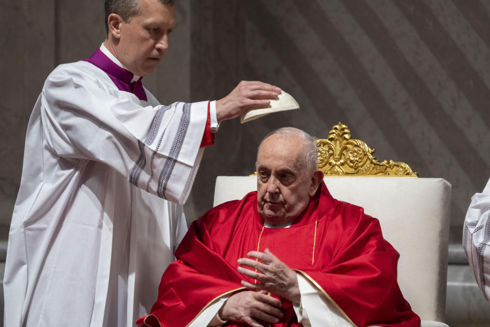 Monsignor Krzysztof Marcjanowicz puts the skull cap on Pope Francis during the liturgy of the passion on Good Friday in St. Peter's Basilica at The Vatican, Friday, Mar. 29, 2024. (AP Photo/Domenico Stinellis)