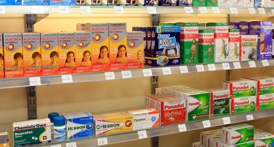 Medicine stacked on supermarket shelves, with brans such as Panadol and Chemists' Own visible.