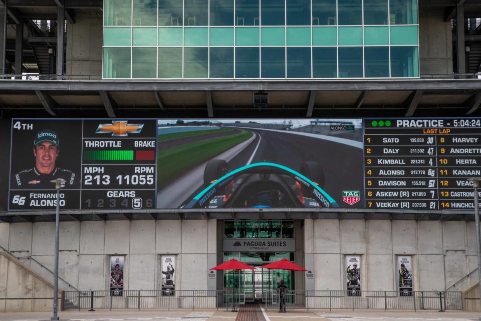 Under a new video board a lone event staffer stands near the entrance to the pagoda during the second day of practice for the 104th Indianapolis 500 at Indianapolis Motor Speedway on Thursday, Aug. 13, 2020. 