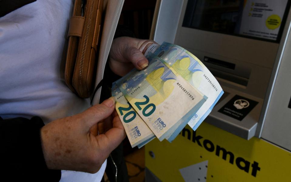 A woman withdraws euro banknotes from an ATM in Zagreb on Jan. 2, 2023. Since January 1, 2023 the euro is the official currency in Croatia.