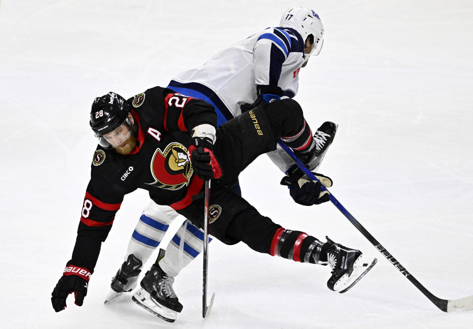 Ottawa Senators right wing Claude Giroux (28) falls after getting tangled with Winnipeg Jets centre Adam Lowry (17) during the third period of an NHL hockey game, Saturday, Jan. 20, 2024, in Ottawa, Ontario. (Justin Tang/The Canadian Press via AP)