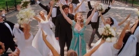 Giselle sings in Central Park surrounded by people in wedding outfits