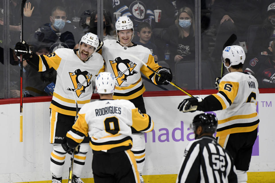Pittsburgh Penguins' Jason Zucker (16) celebrates his goal against the Winnipeg Jets with Danton Heinen (43), Evan Rodrigues (9) and John Marino (6) during the second period of an NHL hockey game Monday, Nov. 22, 2021, in Winnipeg, Manitoba. (Fred Greenslade/The Canadian Press via AP)