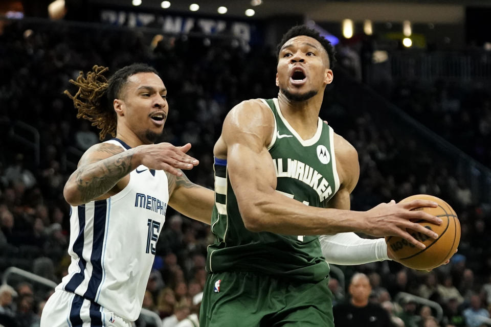 Milwaukee Bucks' Giannis Antetokounmpo, right, drives to the basket against Memphis Grizzlies' Brandon Clarke (15) during the first half of an NBA basketball game Wednesday, April 3, 2024, in Milwaukee. (AP Photo/Aaron Gash)