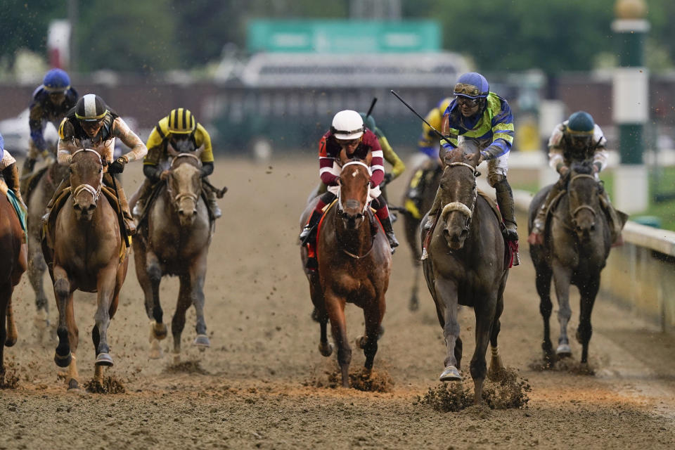 Luis Saez rides Secret Oath, second from right, across the finish line to win the 148th running of the Kentucky Oaks horse race at Churchill Downs Friday, May 6, 2022, in Louisville, Ky. (AP Photo/Charlie Neibergall)