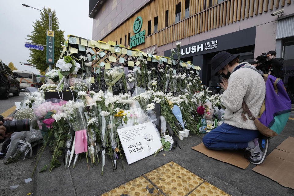 A woman prays for victims of a deadly accident following Saturday night's Halloween festivities on a street near the scene in Seoul, South Korea, Tuesday, Nov. 1, 2022. South Korean police are investigating what caused a crowd surge that killed more than 150 people during Halloween festivities in Seoul over the weekend. (AP Photo/Ahn Young-joon)