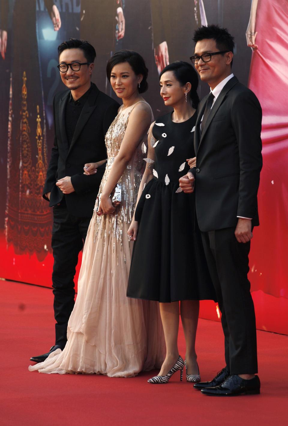 (L-R) Host of the Hong Kong Film Awards Ronald Cheng poses with his wife Sammie and fellow hosts Teresa Mo and Gordon Lam on the red carpet during the 33rd Hong Kong Film Awards in Hong Kong April 13, 2014. REUTERS/Tyrone Siu (CHINA - Tags: ENTERTAINMENT)