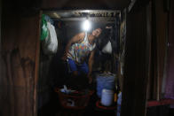 Raimundo da Silva Reis stands on a wooden plank that keeps his belongings above floodwater inside his home flooded by the rise of the Negro river in Iranduba, Amazonas state, Brazil, Monday, May 23, 2022. The Amazon region is being hit hard by flooding with 35 municipalities that are facing one of their worst floods in years and the water level is expected to rise over the coming months. (AP Photo/Edmar Barros)