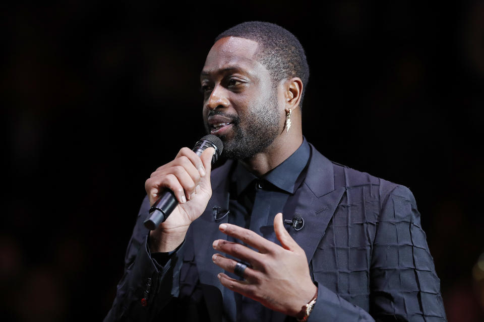 Dwyane Wade holds a microphone.