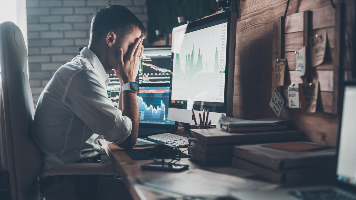 man upset with stock chart on computer screen