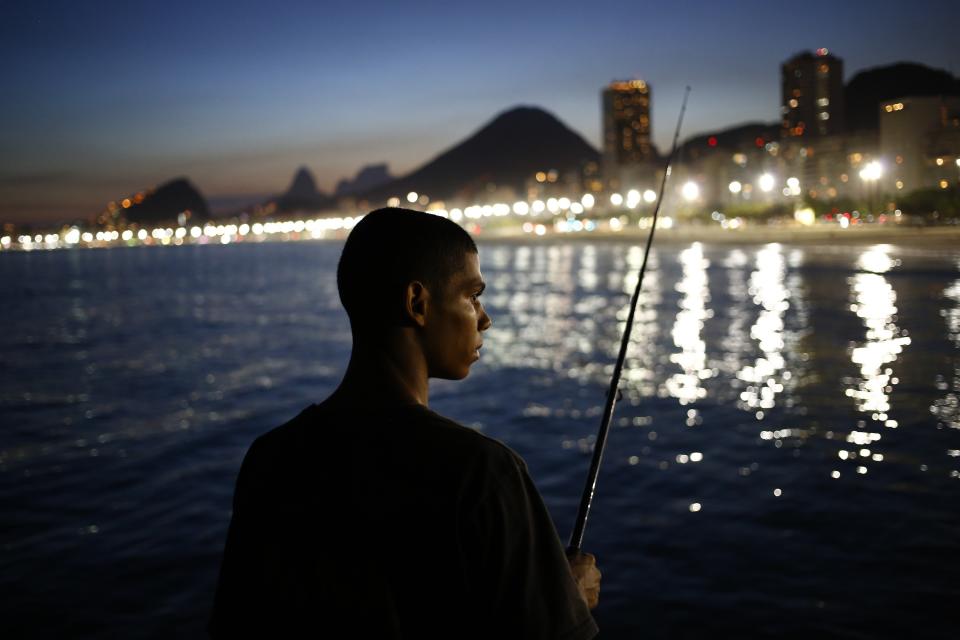 A fisherman waits for a catch in front of the beach of Copacabana in Rio de Janeiro, March 18, 2014. REUTERS/Jorge Silva (BRAZIL - Tags: SOCIETY TPX IMAGES OF THE DAY)